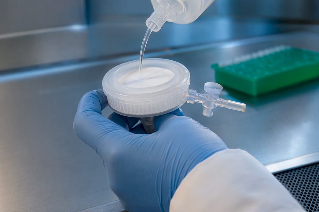 Gloved researcher pre-wetting filtration membrane